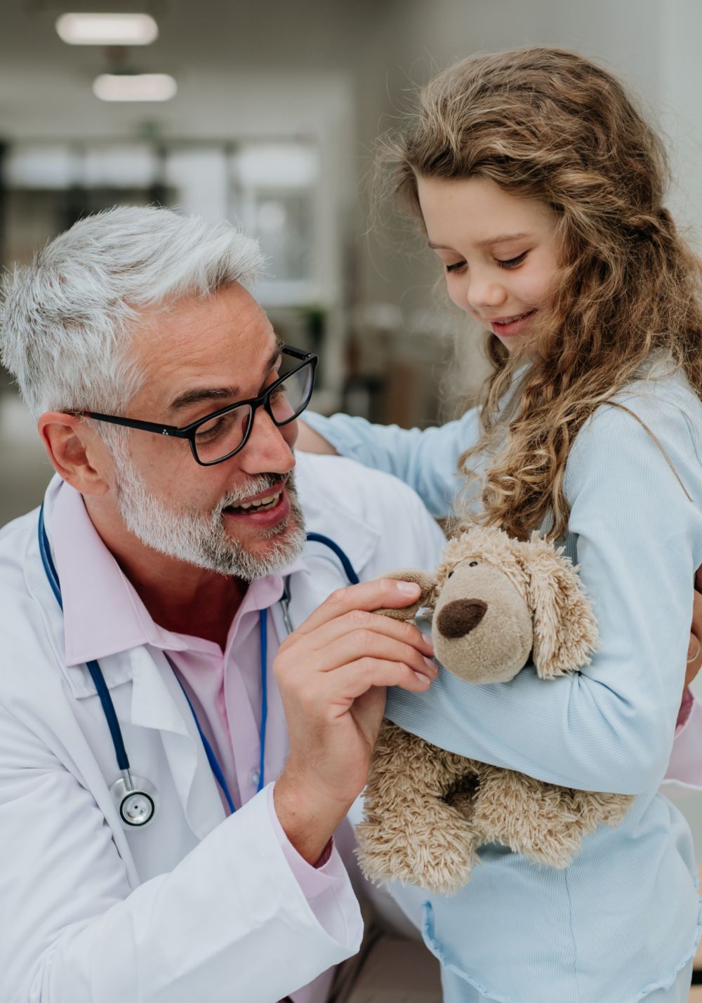 doctor-playing-with-his-little-patient-at-pediatri-BRECGJ6-1.jpg